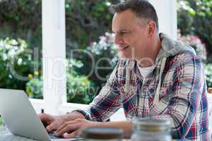 Man using laptop in porch