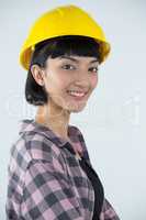 Female architect in hard hat standing against white background