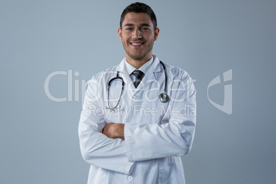 Smiling doctor standing with his hands crossed