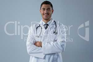 Smiling doctor standing with his hands crossed