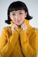 Woman in winter clothing posing against white background