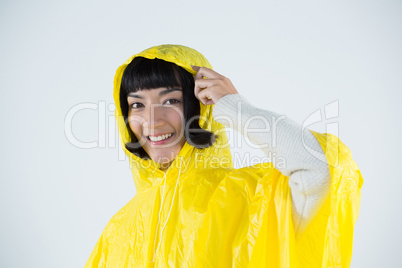 Woman wearing yellow raincoat against white background