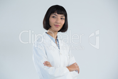 Doctor standing with arms crossed against white background Doctor standing with arms crossed against white background