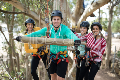 Friends enjoying zip line adventure in park