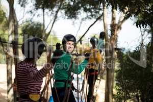 Friends enjoying zip line adventure in park