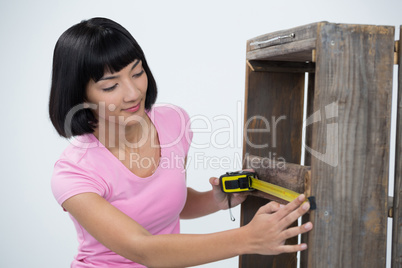 Woman measuring furniture with tape measure