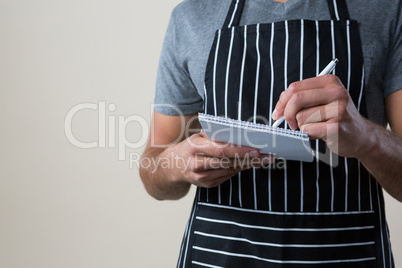 Waiter writing down an order in the notepad