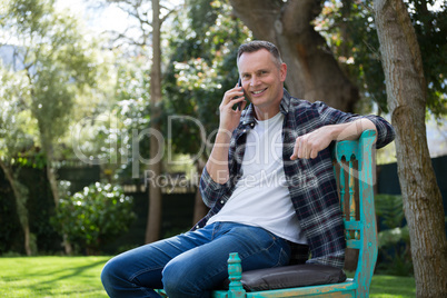 Man talking on mobile phone in garden