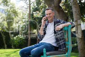 Man talking on mobile phone in garden