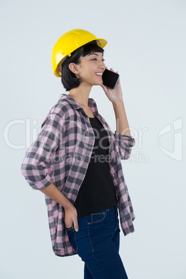 Female architect talking on mobile phone against white background