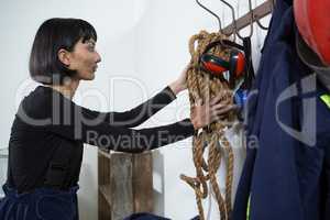 Female architect removing rope from hanger