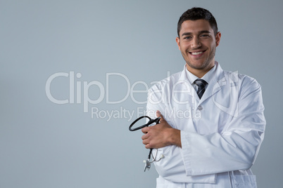 Smiling doctor standing with his hands crossed