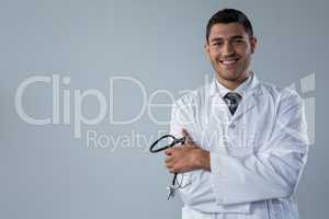Smiling doctor standing with his hands crossed