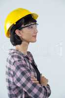 Female architect standing with arms crossed against white background