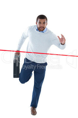 Male executive with briefcase running towards finish line