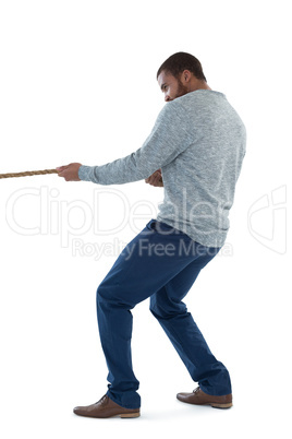 Male executive pulling the rope against white background