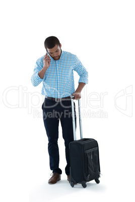 Male executive with luggage talking on mobile phone Male executive with luggage talking on mobile phone
