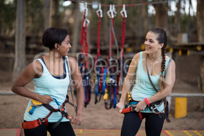 Female friends getting their belt tied to perform zip line