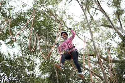 Woman enjoying zip line adventure in park