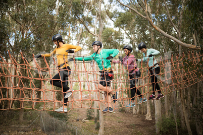 Friends walking on rope bridge