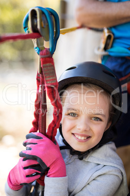 Cute girl enjoying zip line adventure on sunny day