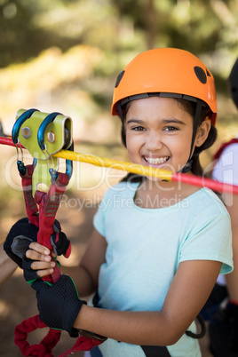 Cute girl enjoying zip line adventure on sunny day