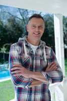 Man standing with arms crossed in porch