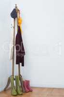 Hat, umbrella, jumper, grocery bags and wellington boots on wooden stand