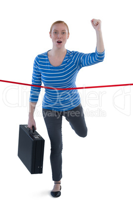 Female executive with a brief case crossing the finish line