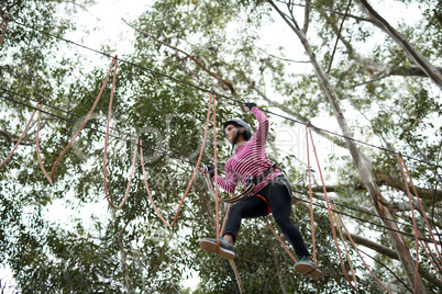 Woman enjoying zip line adventure in park