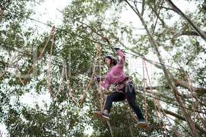 Woman enjoying zip line adventure in park