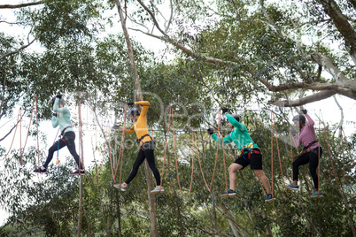 Friends enjoying zip line adventure in park