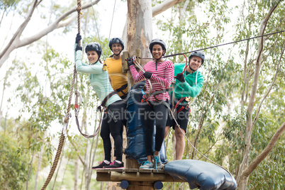 Friends ready to zip line in park on a sunny day