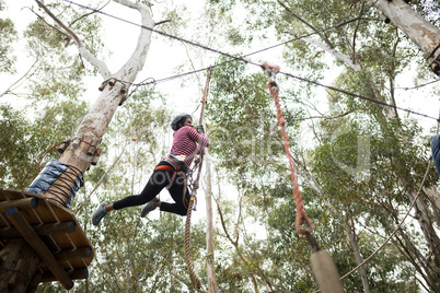 Woman enjoying zip line adventure in park