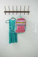 Turquoise dress and school bag hanging on hook