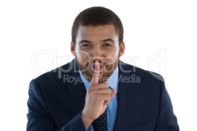 Businessman standing with finger on lips