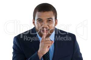 Businessman standing with finger on lips
