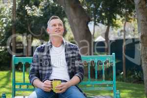 Thoughtful man having cup of coffee in garden