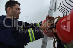 Fireman taking the safety helmet from the hook