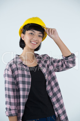 Female architect in hard hat standing against white background Female architect in hard hat standing against white background