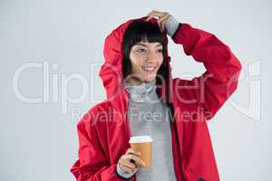 Woman in red jacket having coffee against white background