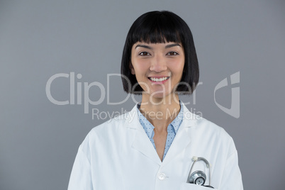 Doctor standing against grey background