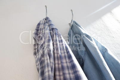 Shirts hanging on hook against wall