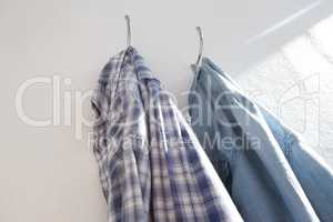 Shirts hanging on hook against wall