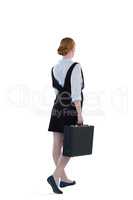 Female executive walking with suitcase