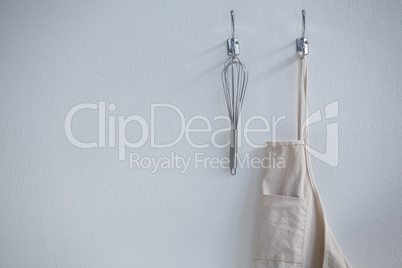 Apron and whisker hanging on hook