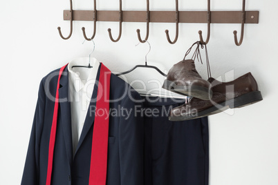 Close-up of full suit and shoes hanging on hook
