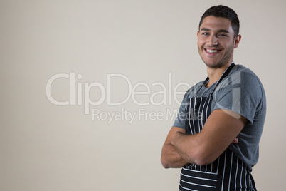 Smiling waiter standing with his hands crossed