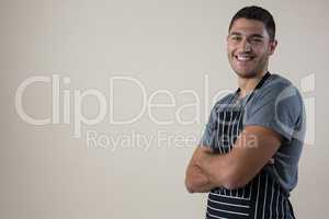 Smiling waiter standing with his hands crossed