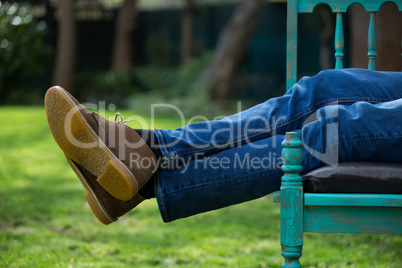 Man lying on bench in garden